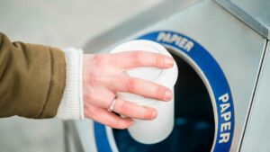 femme qui jette son gobelet dans une poubelle