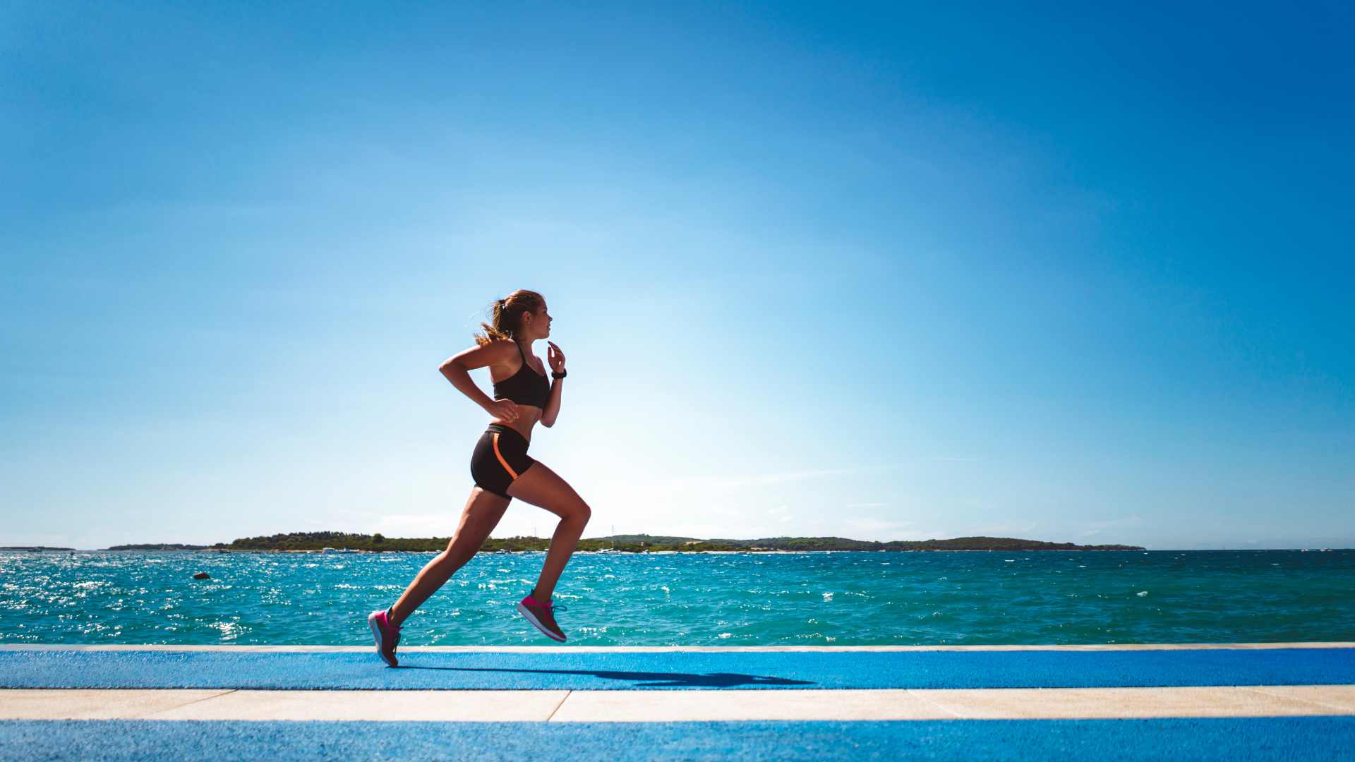 femme qui cours au bord de la plage