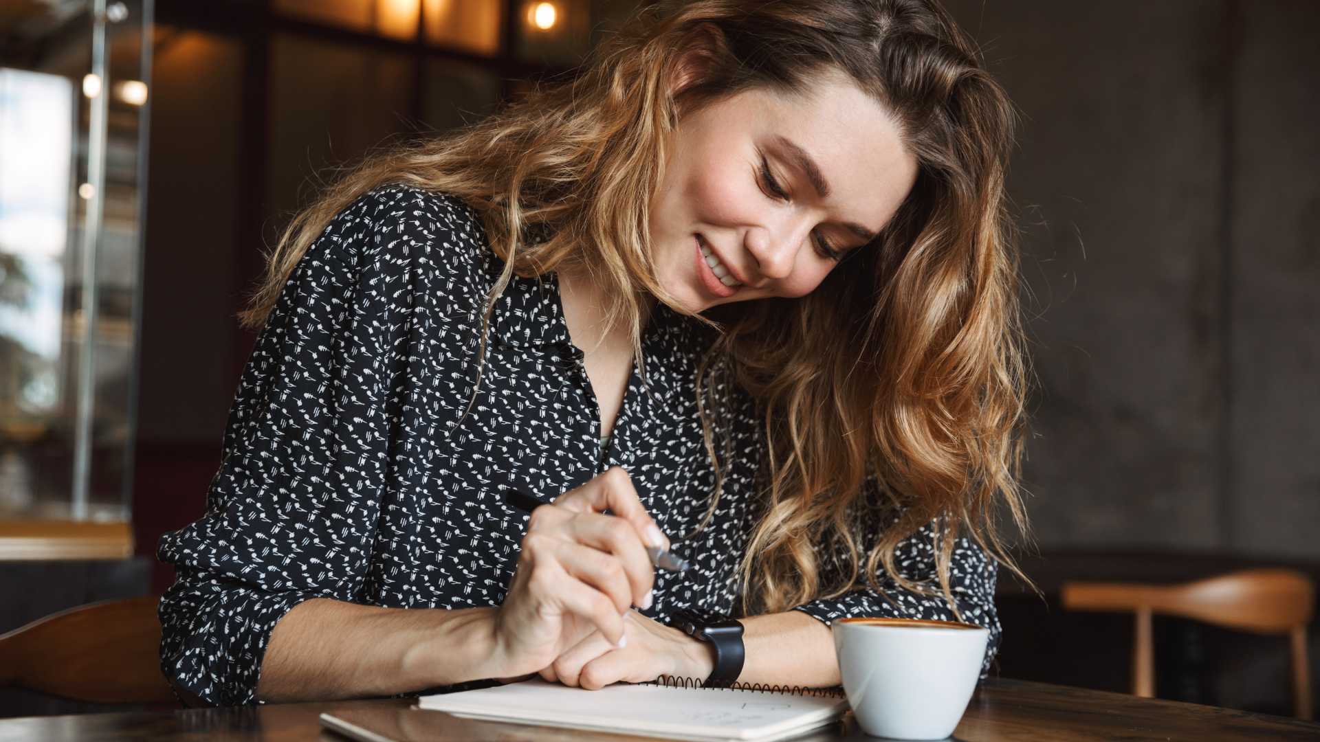 femme qui écrit dans un café